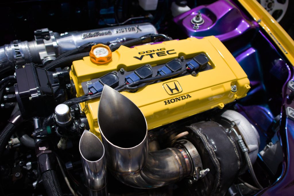 Turbocharged Honda DOHC VTEC engine with yellow valve cover and Edelbrock intake manifold Wallpaper