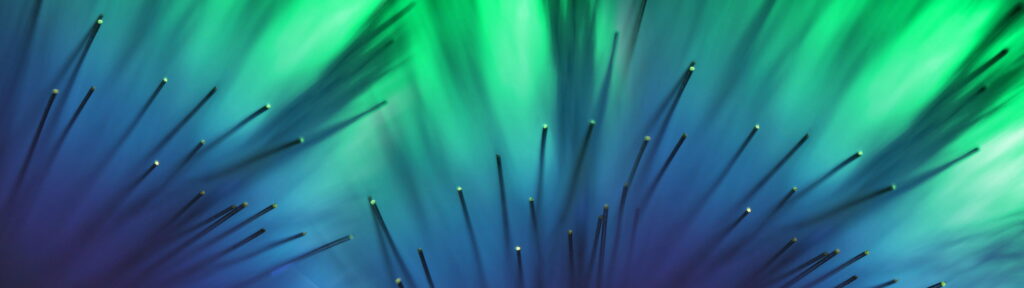 Macro wallpaper of glowing fiber optic strands with vibrant green and deep blue gradient background