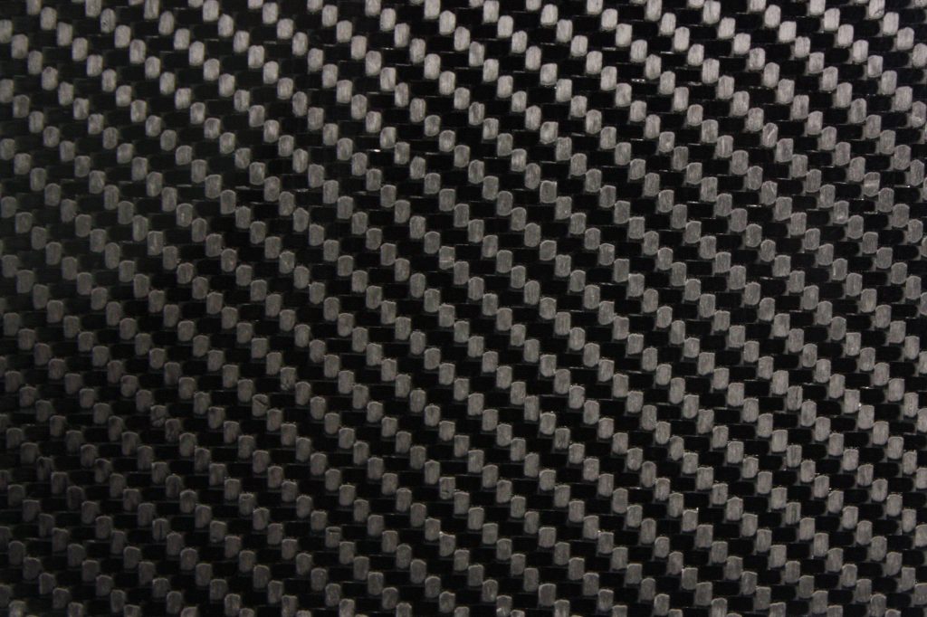 Close-up of sleek black and gray carbon fiber weave texture high-resolution industrial wallpaper background