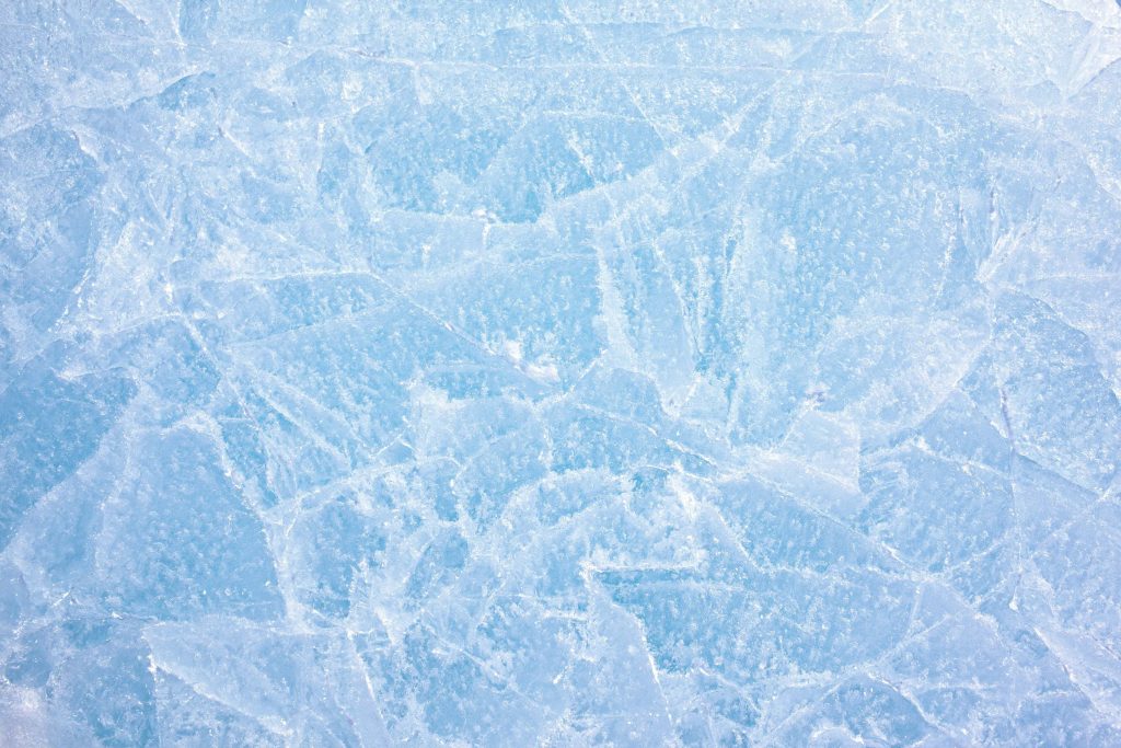 High-resolution ice texture with detailed cracks and bubbles in icy blue and white tones Wallpaper