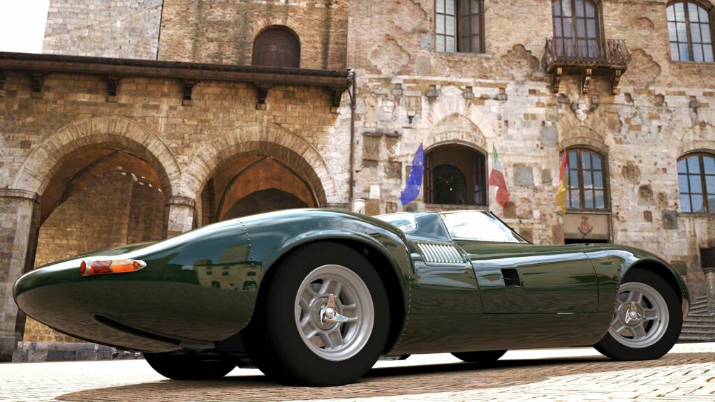 Jaguar XJ13 Racing Car Wallpaper with Rustic Stone Building Background