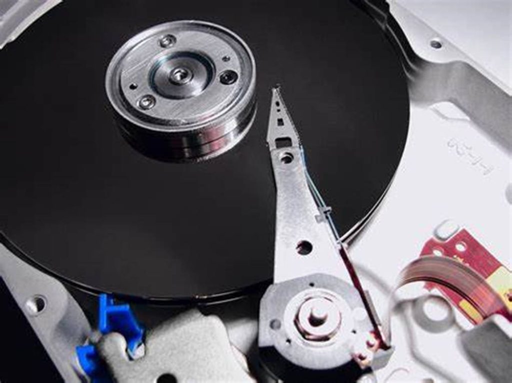 Close-up overhead view of a computer hard disk drive HDD with detailed platter and actuator arm Wallpaper