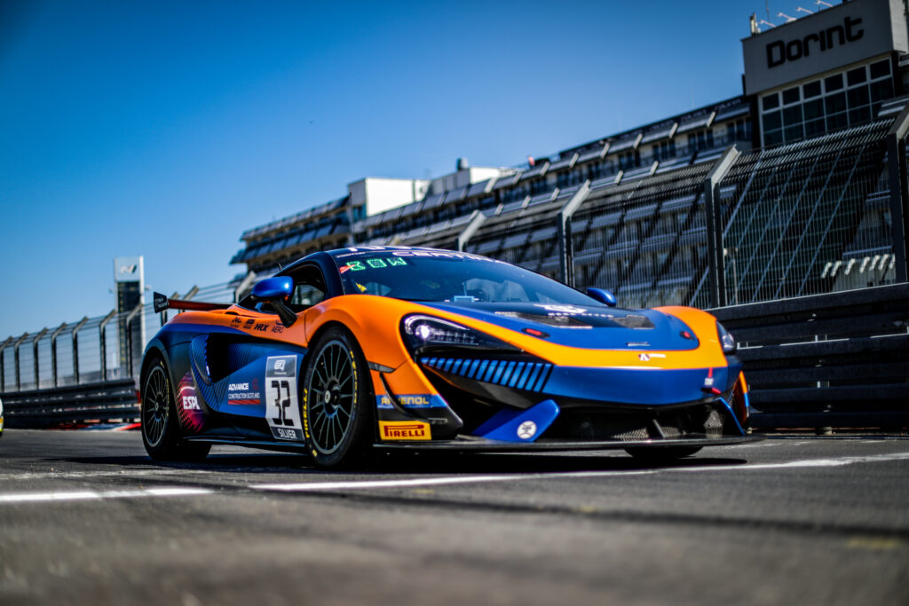 Vibrant McLaren Sports Car Wallpaper - Sleek Racetrack Design