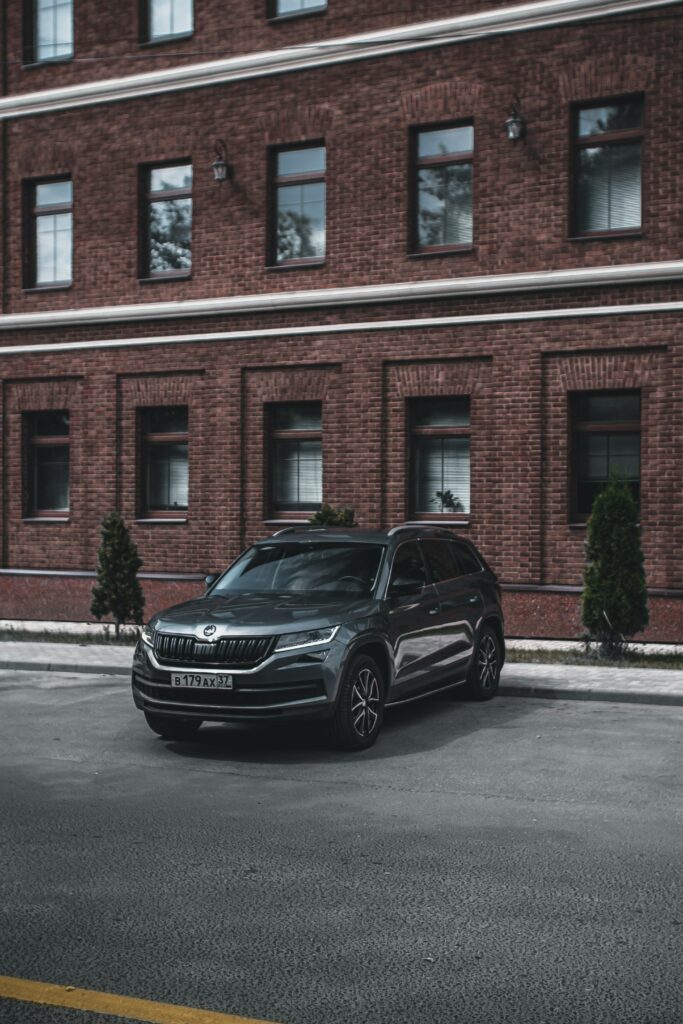 Modern SUV Against Classic Brick Building - High-Res Wallpaper
