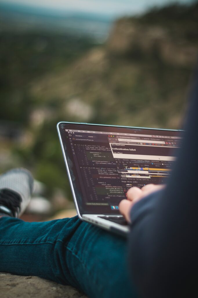 Serene Outdoor Coding: High-Res Wallpaper of Programmer with Laptop