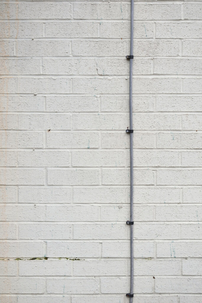 High-Res White Brick Wall Texture with Vertical Cable Wallpaper