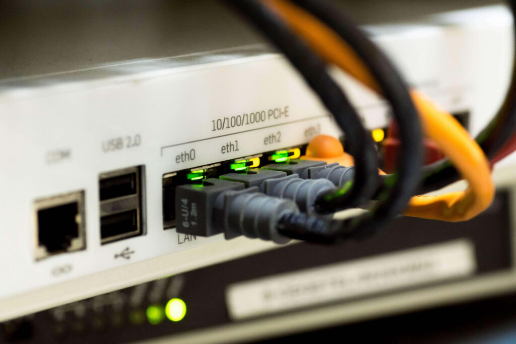 Close-up of network switch with multiple Ethernet cables and glowing green indicator lights wallpaper
