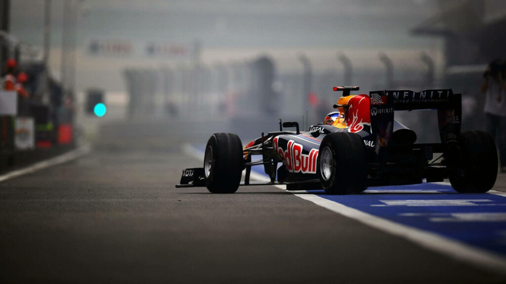 F1 racing car speeding on track high speed intense Formula 1 race dynamic wallpaper background