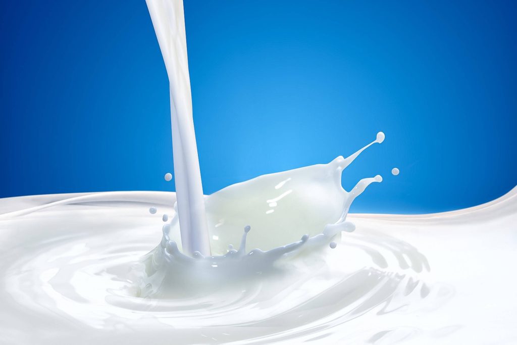 High-speed milk splash with crown and ripples on vibrant blue background refreshing wallpaper