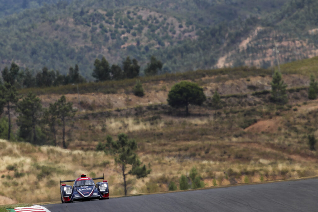 Thrilling Racing Car on Track with Scenic Mountain Background Wallpaper