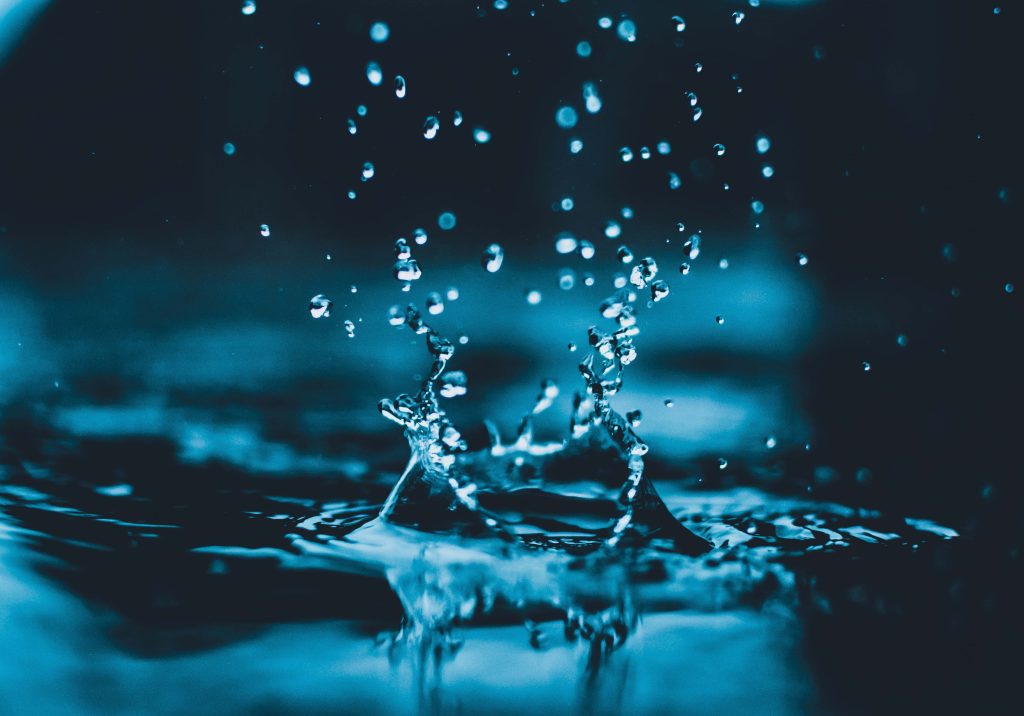 High-speed water splash wallpaper with turquoise navy droplets capturing fluid ocean motion