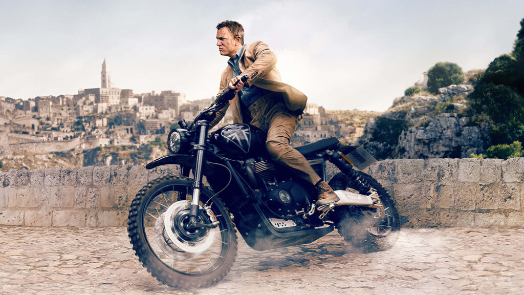 High-Stakes Motorcycle Chase Wallpaper in Urban Landscape