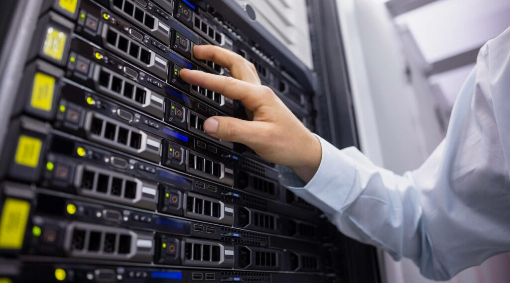 Hand managing black server racks in high-tech data center with visible ports and network components Wallpaper