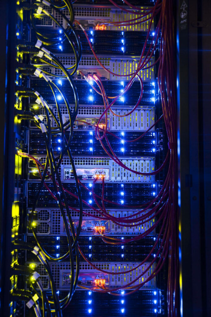 High-tech data center with blue LED servers and organized red network cables digital connectivity Wallpaper