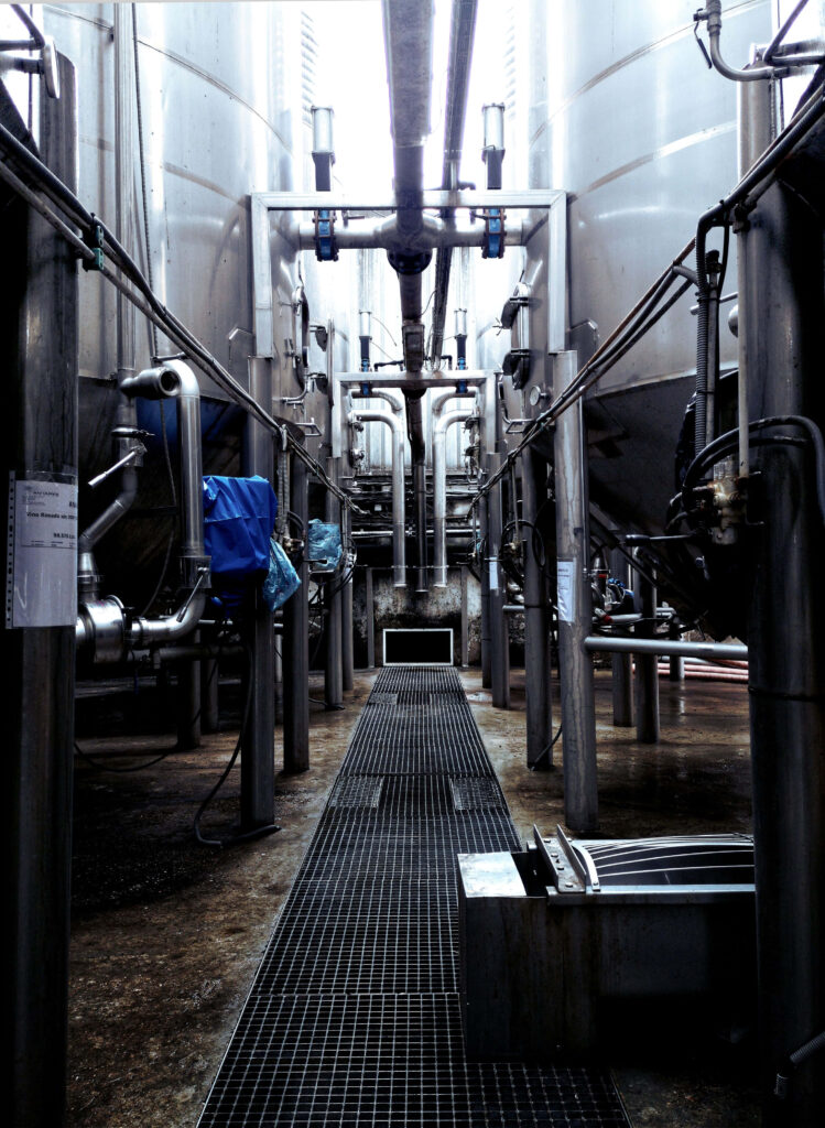 Industrial factory wallpaper with silver tanks pipes and grated walkway in modern high-tech plant
