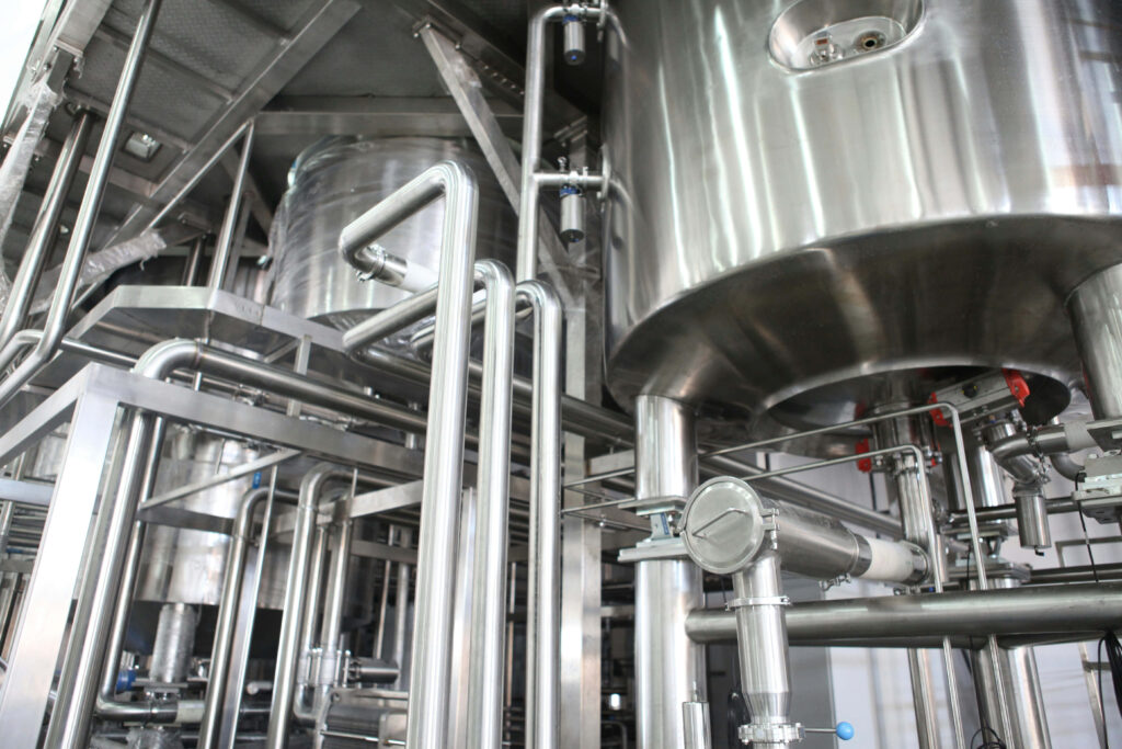 Modern factory interior with stainless steel tanks pipes and advanced manufacturing equipment wallpaper
