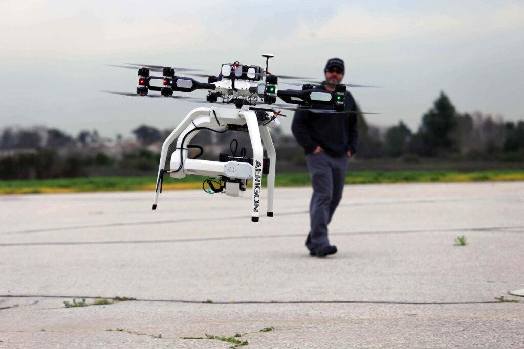 High-tech multi-rotor drone with LED lights hovering over runway advanced aerial technology Wallpaper