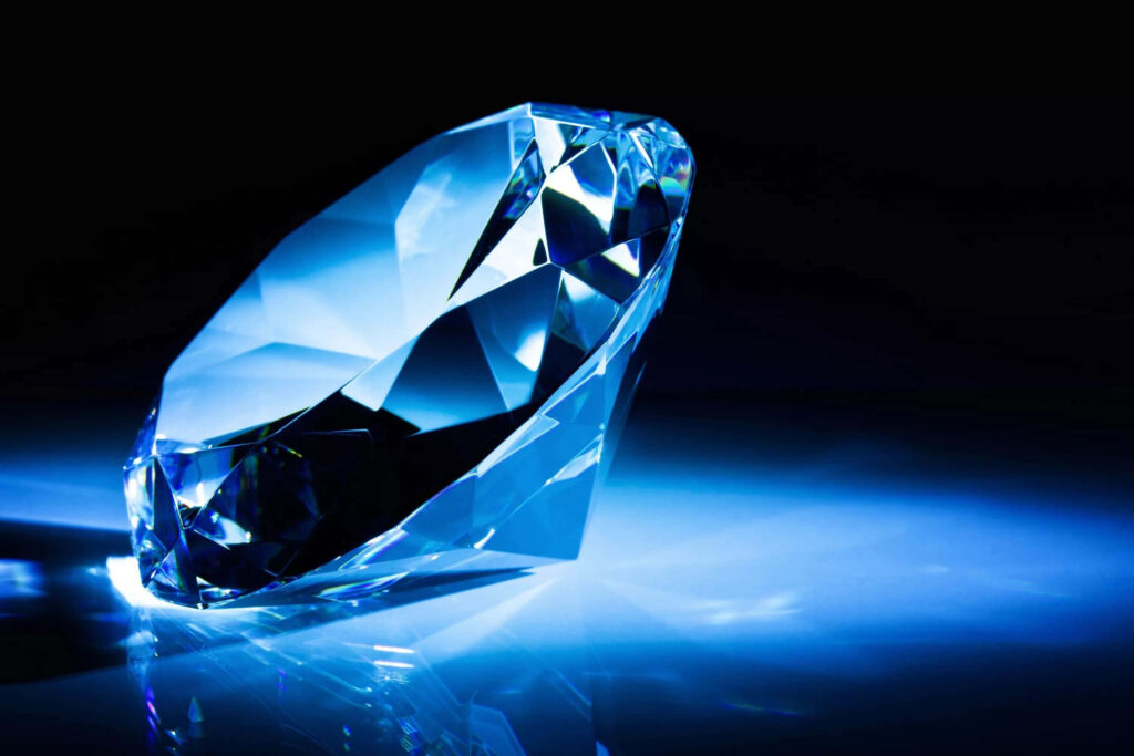 High-definition diamond wallpaper with large faceted gem on reflective surface in blue light