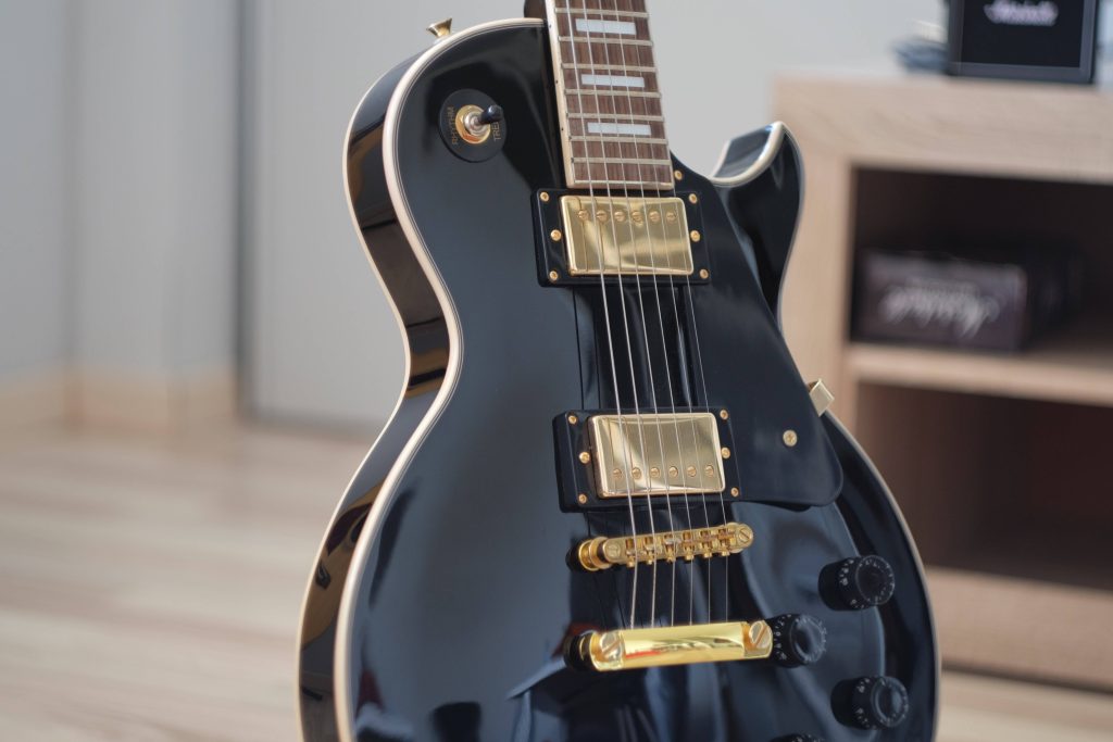 High resolution black Les Paul electric guitar with gold hardware and cream binding wallpaper