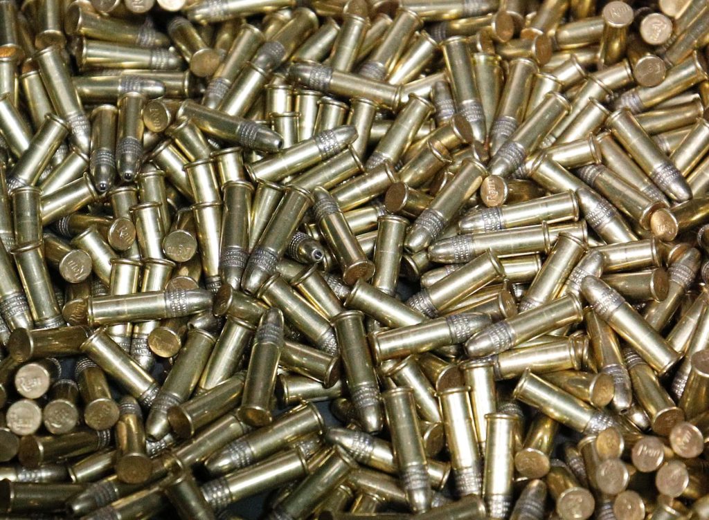 High-resolution photo of brass Remington 22 LR rimfire cartridges with reflective metallic casings Wallpaper