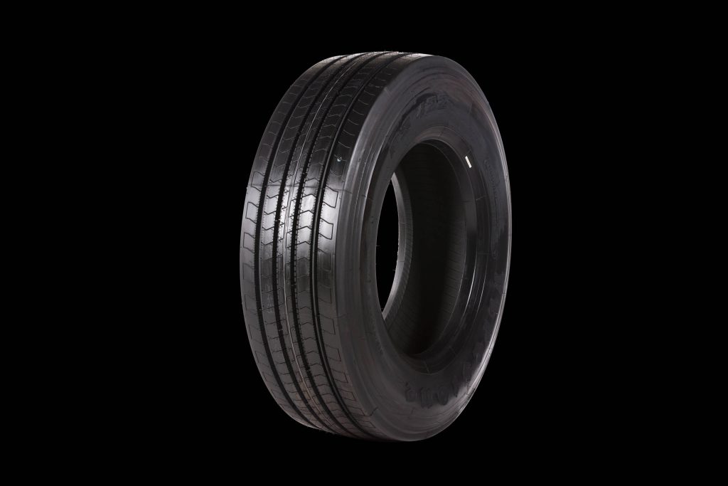 High-resolution Firestone FS422 commercial truck tire studio shot with detailed tread on black background Wallpaper
