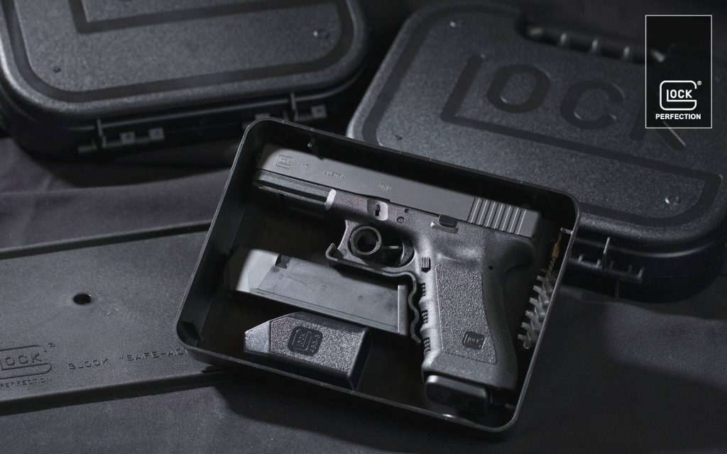 High-resolution Glock 17 9mm pistol in official black hard case with tactical studio background Wallpaper