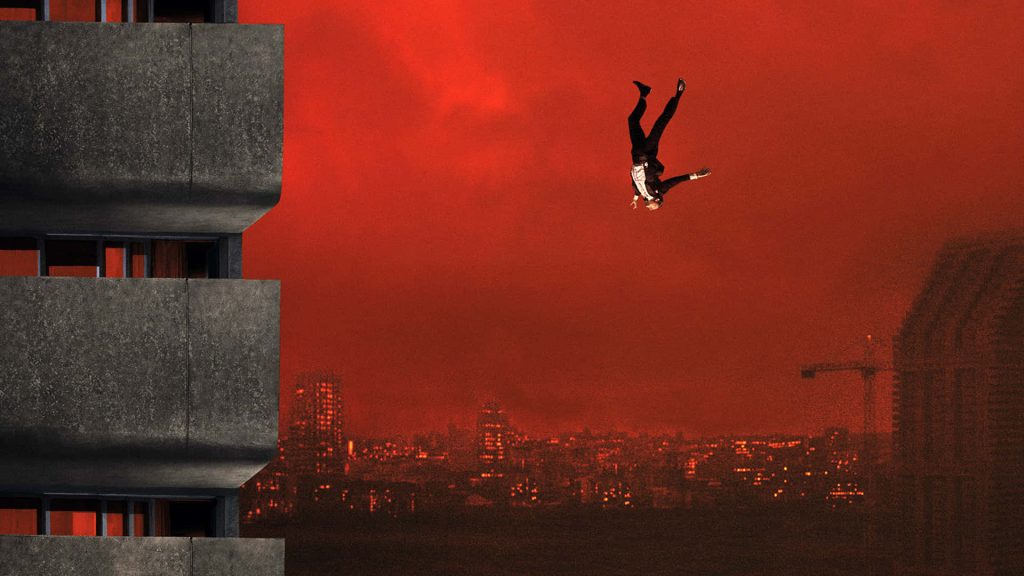 Masked figure falling against blood red sky and concrete high rise buildings wallpaper background