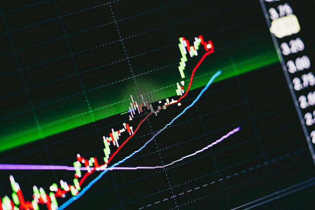 Close-up digital stock market chart with glowing red green candlesticks on dark grid background Wallpaper