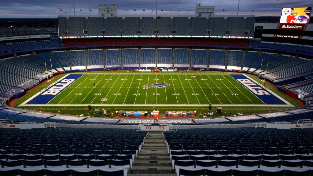 Highmark Stadium at dusk with vibrant blue end zones and Buffalo Bills logo football field view Wallpaper