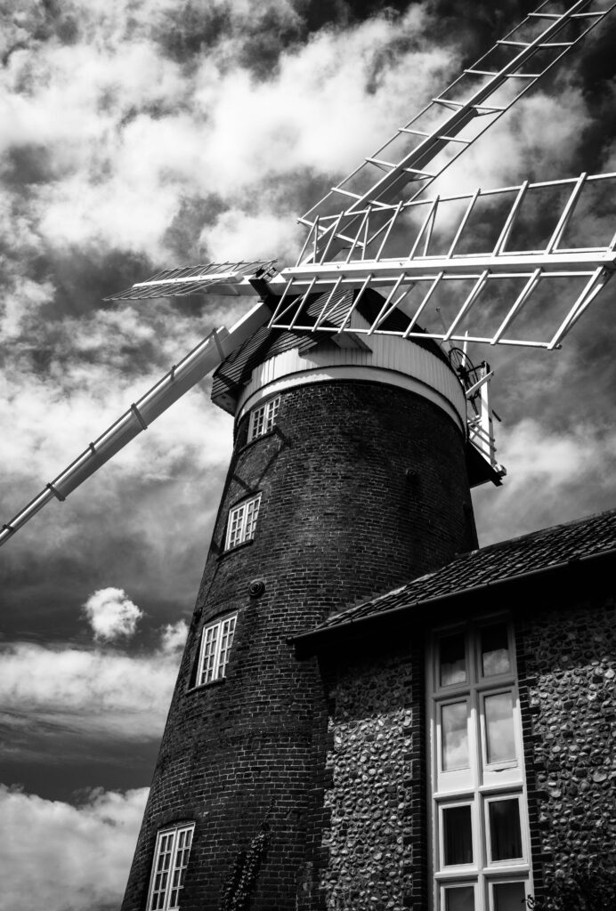 Historic Black and White Wallpaper of Towering Mill Against Dramatic Sky