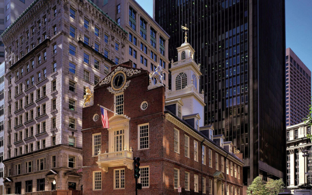 Historic Colonial Building Amid Modern Skyscrapers - Wallpaper Background