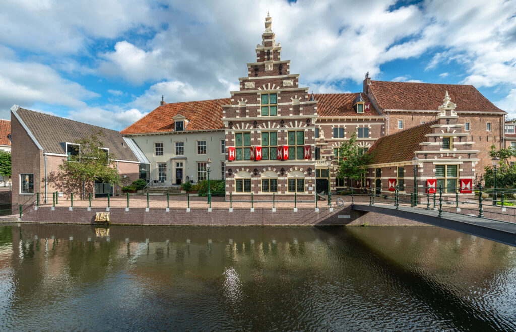 Historic Dutch building with stepped gables and red shutters by calm Amersfoort canal wallpaper