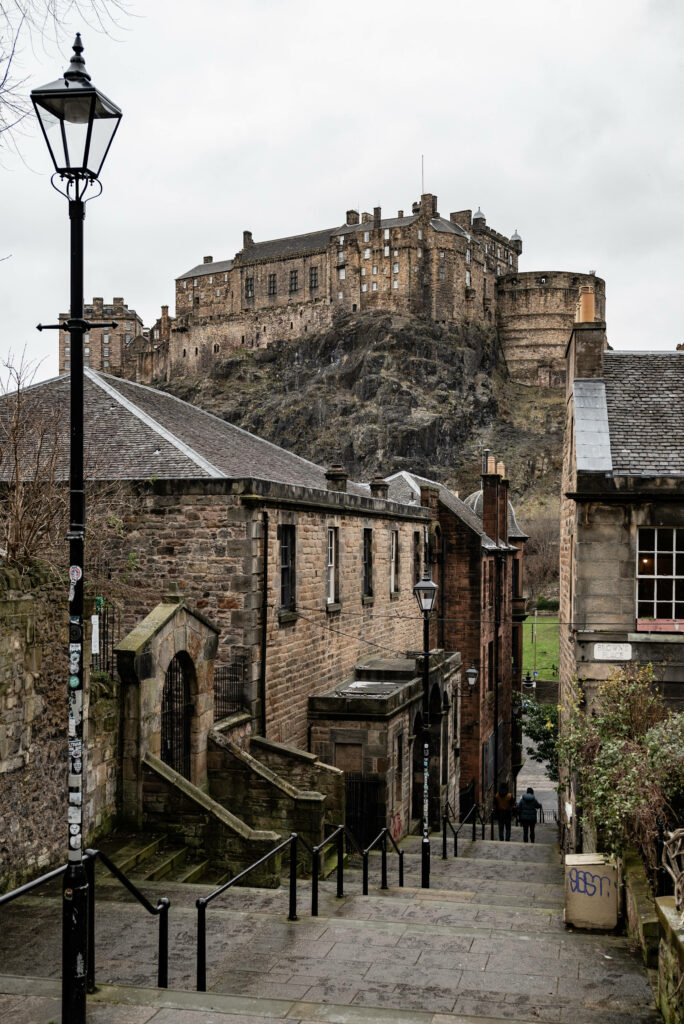Historic Edinburgh Castle view with old stone buildings and classic lamppost under overcast sky Wallpaper