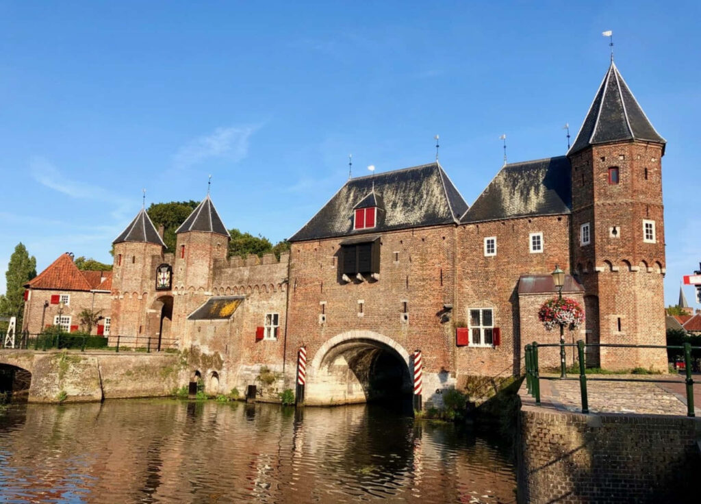 Historic Koppelpoort medieval gate in Amersfoort Netherlands with brick architecture reflection Wallpaper