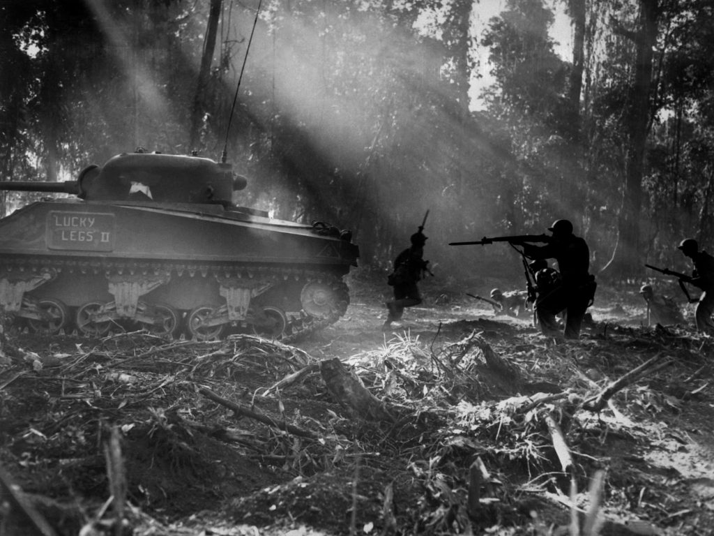 Black and white WWII jungle combat scene with M4 Sherman Lucky Legs II tank and US infantry Wallpaper