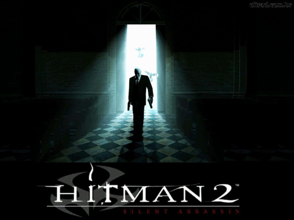 Agent 47 in black suit and red tie dual-wielding pistols in dark church arched doorway wallpaper