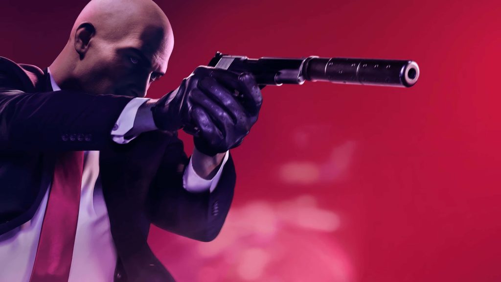 Agent 47 in black suit with red tie aiming suppressed pistol on deep red Hitman 3 wallpaper