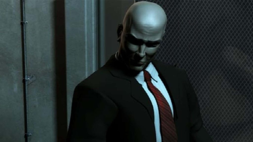 Hitman Agent 47 in black suit and red tie standing in moody industrial CGI background wallpaper