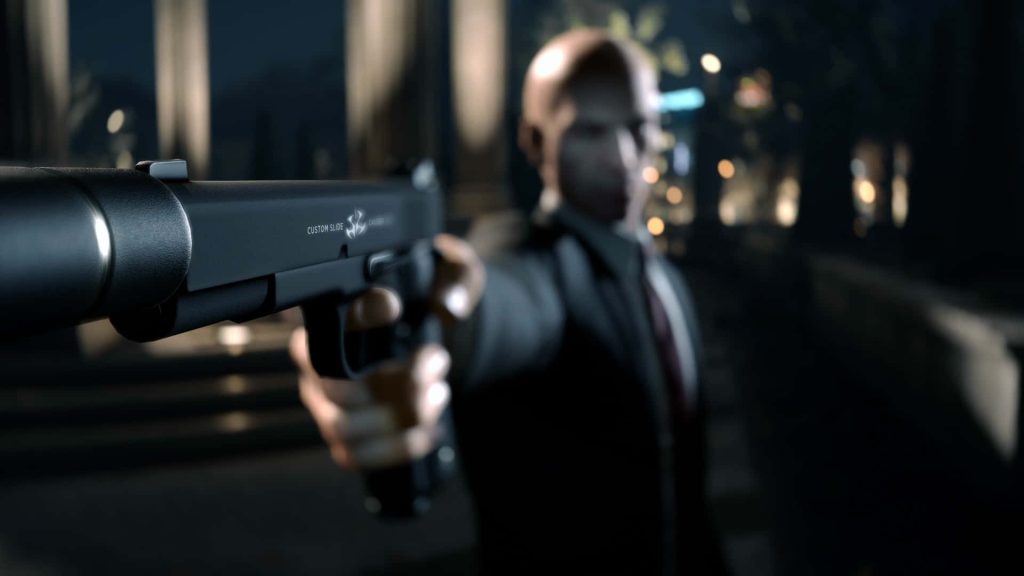Hitman Agent 47 wallpaper with sharp Silverballer pistol foreground and blurred assassin background