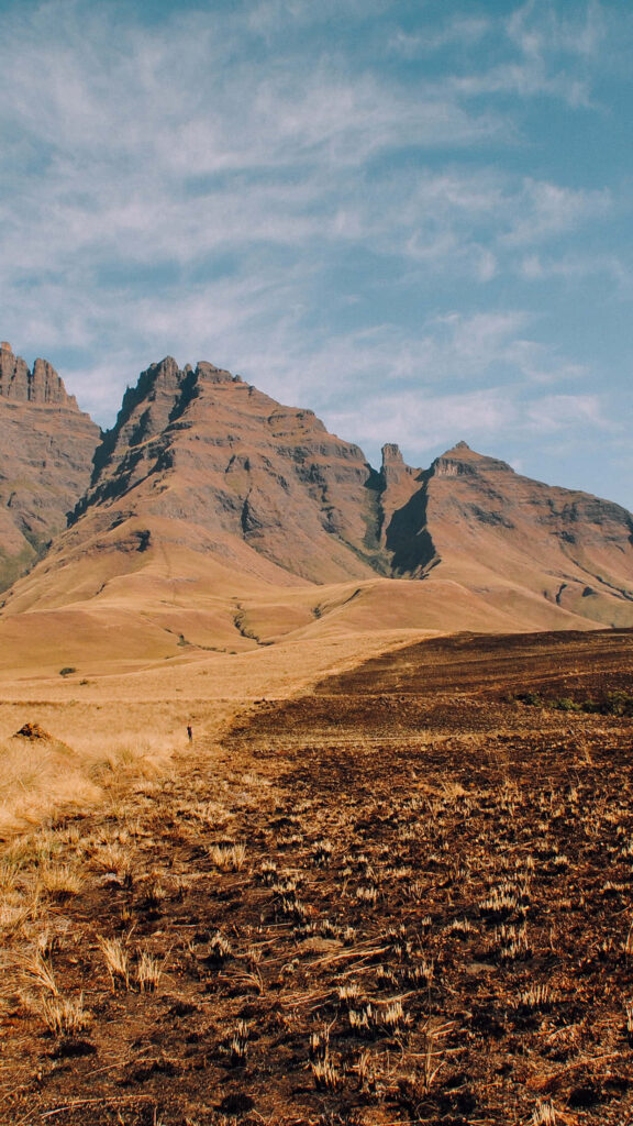 Hoggar Mountains wallpaper with rugged terrain and earthy soil under clear blue sky background