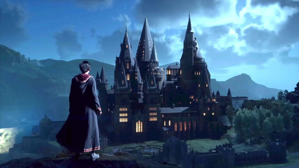 Student in Hogwarts robes overlooking illuminated Hogwarts castle at night magical Hogwarts Legacy Wallpaper