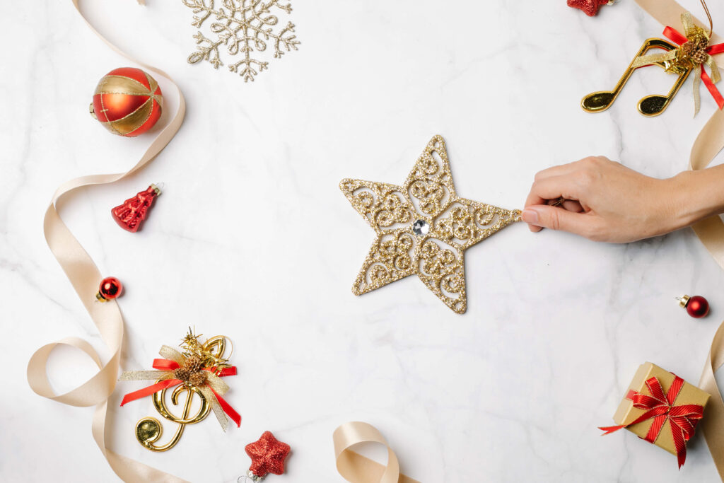 Magical Festive Scene: Captivating Hand-Held Star Ornament Shines Against Elegant White-Textured Backdrop Wallpaper