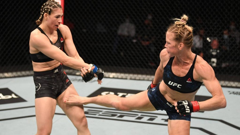 Holly Holm kicks Irene Aldana in UFC Octagon intense MMA championship fight action wallpaper