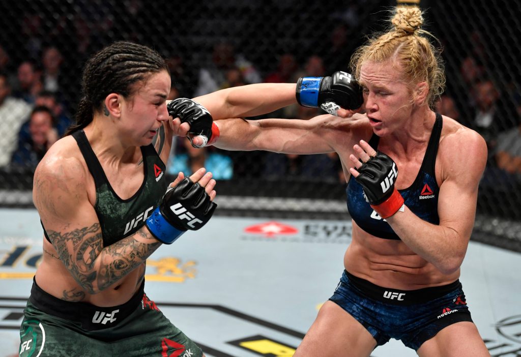 Holly Holm punches Raquel Pennington in UFC fight Octagon intense female MMA action wallpaper