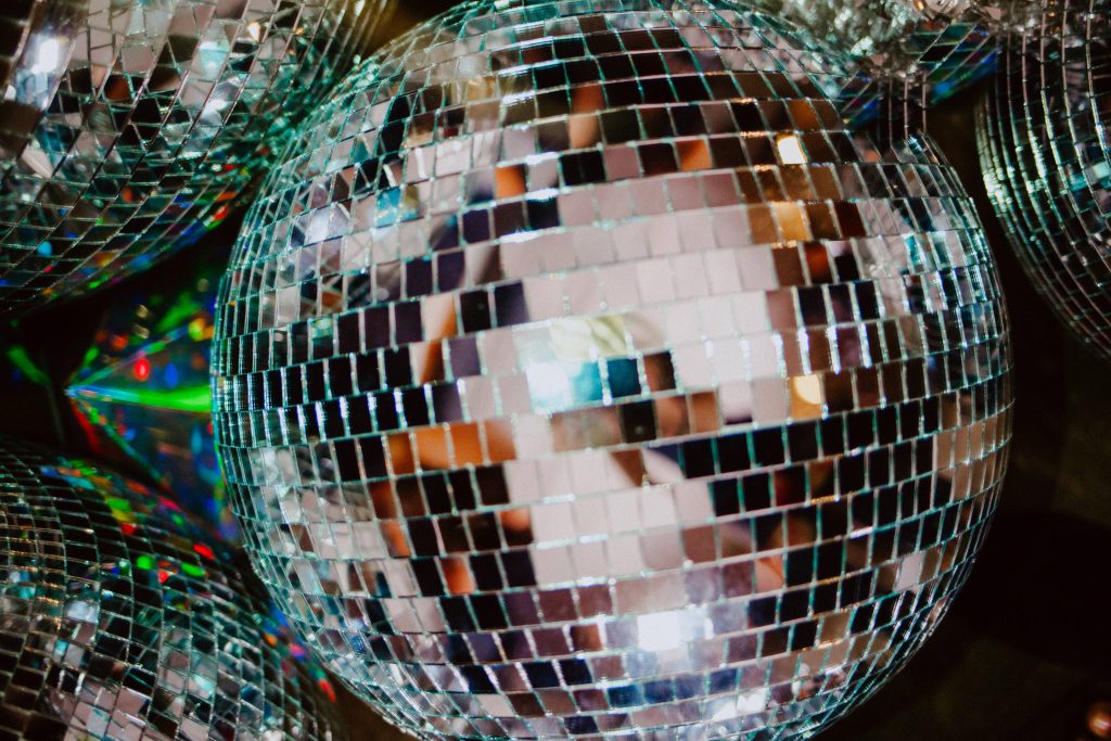 Disco ball holographic wallpaper with mirrored tiles and vibrant shimmering light reflections background