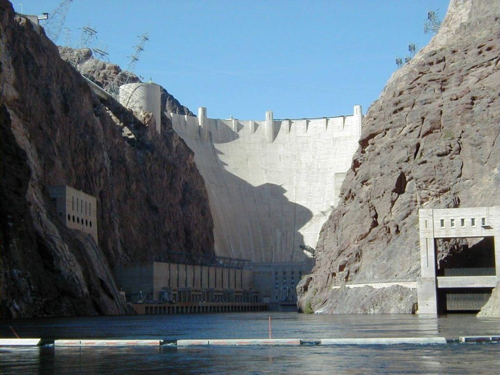 Hoover Dam towering between sunlit canyon cliffs over the Colorado River historic landmark wallpaper
