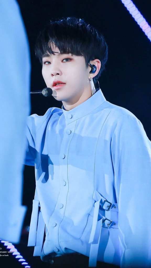 Hoshi SEVENTEEN in light blue shirt performing live on stage with dramatic dark backdrop lighting Wallpaper