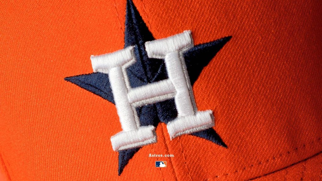 Houston Astros cap logo close-up on vibrant orange MLB gear textured wallpaper background