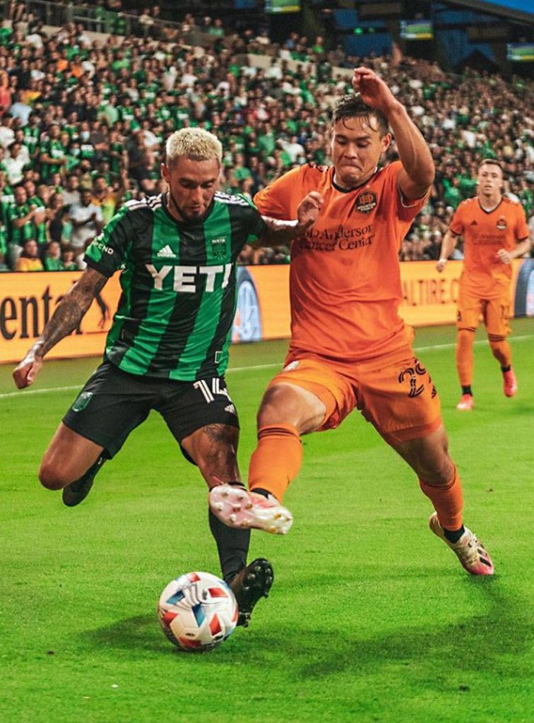 Houston Dynamo player in orange battles Austin FC rival in intense MLS soccer match wallpaper