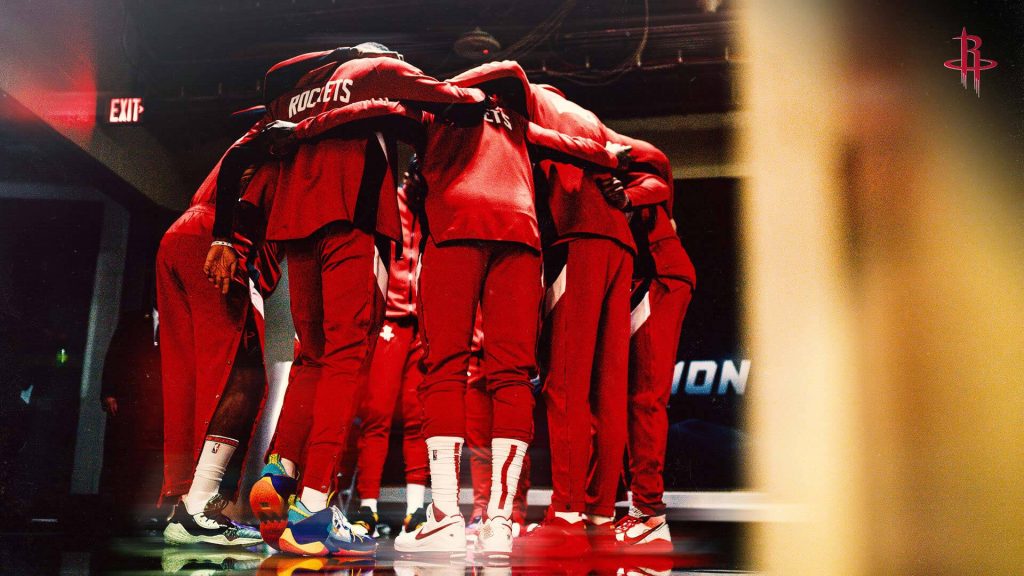 Houston Rockets players in red tracksuits huddle pre-game vibrant NBA arena sports wallpaper
